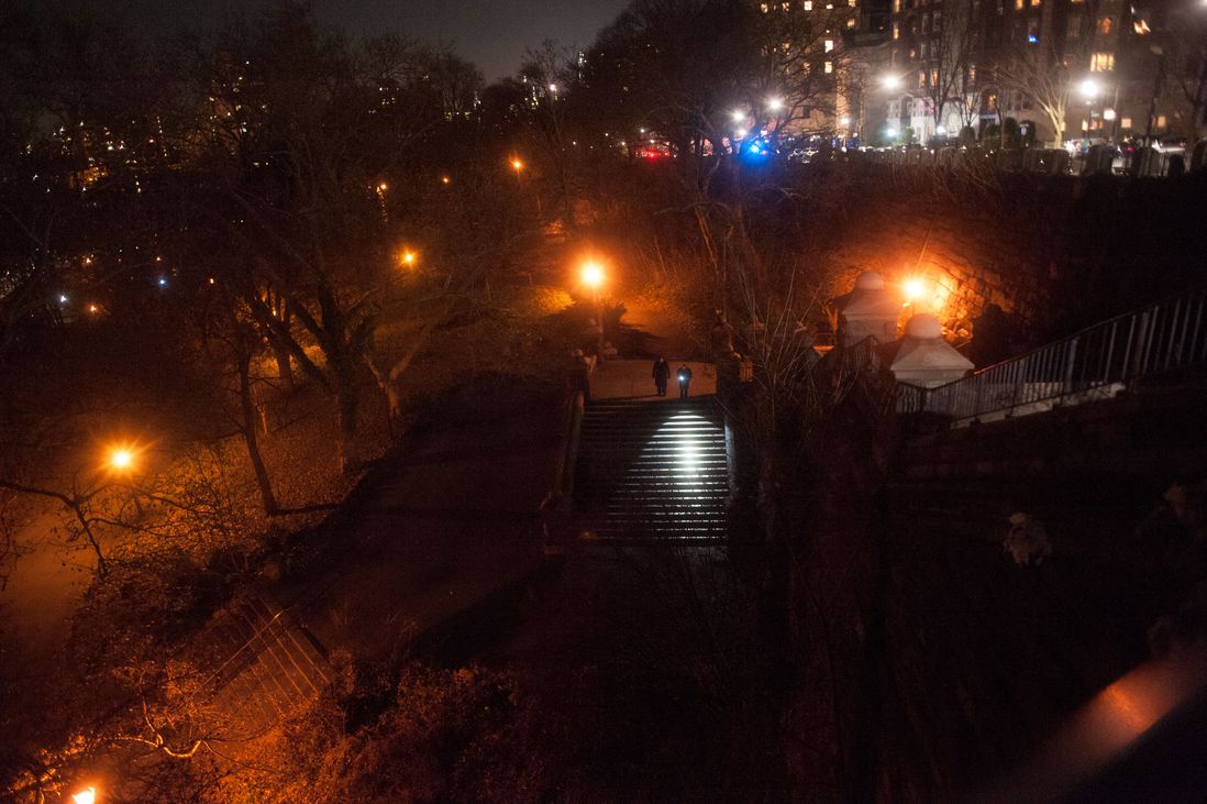 Police officers use a flashlight in Morningside Park after sundown